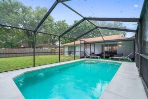 a swimming pool in a yard with a house at Stunning Heated Pool House Close to Tampa in Seffner