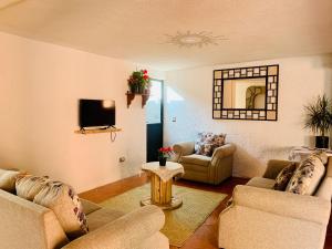a living room with two couches and a tv at Casa Rústica in Atlixco