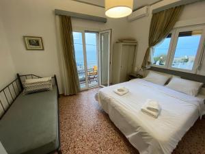 Un dormitorio con una gran cama blanca y una ventana en Sunset view Rooms, en Agia Triada