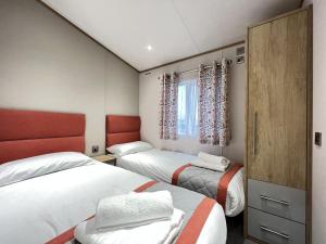 a hotel room with two beds and a window at Stewarts Resort Lodge 23 in St. Andrews