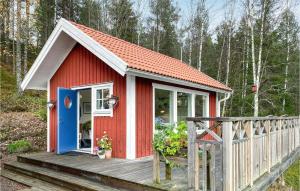 ein rotes und weißes Haus mit einer Holzterrasse in der Unterkunft Amazing Home In Bottnaryd With Wifi in Bottnaryd
