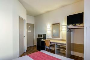 a hotel room with a desk and a microwave at Motel 6-Sidney, NE in Sidney