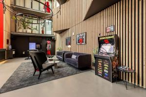 a living room with a video game and a couch at Radisson RED Aarhus in Aarhus