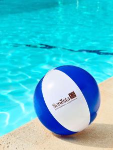 una bola de voleibol azul y blanco sentada junto a una piscina en Sonesta ES Suites Cincinnati - Sharonville West en Sharonville