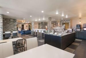 a restaurant with a bar with chairs and tables at SureStay Plus Hotel by Best Western Coralville Iowa City in Coralville