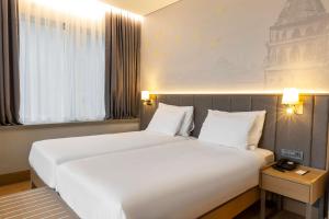 Un pat sau paturi într-o cameră la Radisson Hotel Istanbul Harbiye