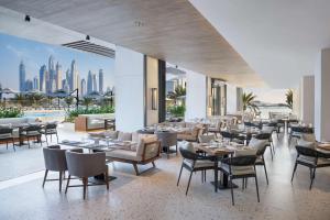 a restaurant with tables and chairs and a view of the city at Radisson Beach Resort Palm Jumeirah in Dubai