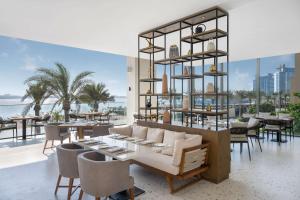 a restaurant with tables and chairs and a view of the ocean at Radisson Beach Resort Palm Jumeirah in Dubai