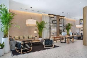 a living room with a couch and tables and chairs at Radisson Beach Resort Palm Jumeirah in Dubai