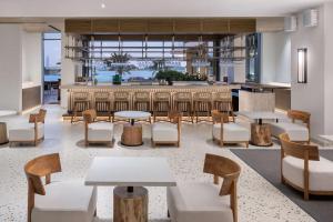 a lobby with tables and chairs and a bar at Radisson Beach Resort Palm Jumeirah in Dubai