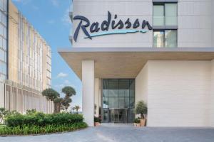 a building with a sign on the side of it at Radisson Beach Resort Palm Jumeirah in Dubai