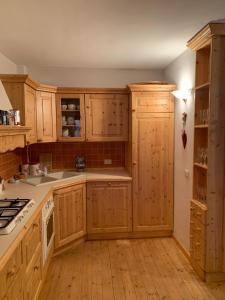 a kitchen with wooden cabinets and white appliances at Incantevole 90MQ sulle piste di Limonetto in Limone Piemonte