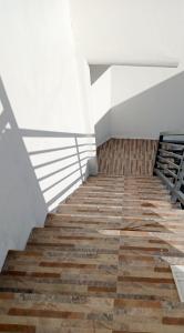 a staircase with wooden floors and a white wall at __APlaridel Inn Suites__ in Angeles