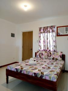 a bedroom with a large bed with a colorful bedspread at __APlaridel Inn Suites__ in Angeles