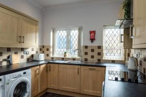 a kitchen with a washing machine and a washer at Cheerful 5 bed Property in Llanelli in Llanelli