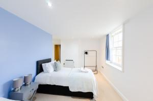 a white bedroom with a large bed and a window at Large Apartment - Eleven Charlotte House x 2 Bathrooms in Ipswich