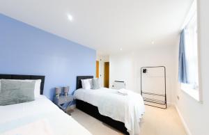 - une chambre blanche avec 2 lits et un miroir dans l'établissement Large Apartment - Eleven Charlotte House x 2 Bathrooms, à Ipswich