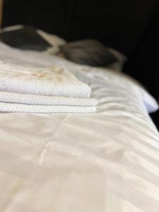 a stack of white towels sitting on top of a bed at Апартаменти VIP в центрі Чорткова in Chortkiv