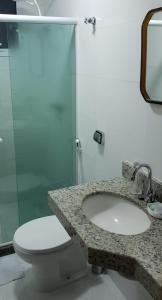 a bathroom with a toilet and a sink and a shower at Vista espectacular 180° Murano Praia do Morro in Guarapari