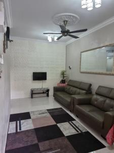 a living room with a couch and a flat screen tv at Maisarah Homestay Melaka, Islamic Home in Melaka in Melaka