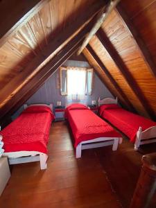 2 camas en un ático con sábanas rojas en Complejo Cascadas de Artalaz en Colón