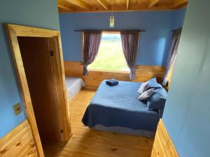 a small bedroom with a bed and a window at Vista al Paine - Refugio de Aventura in Torres del Paine
