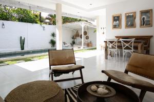 ein Wohnzimmer mit Stühlen und einem Tisch in der Unterkunft Villa Paz Bali in Canggu