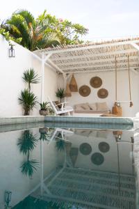 Villa mit einem Pool mit einem Bett und Palmen in der Unterkunft Villa Paz Bali in Canggu
