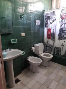 Baño de azulejos verdes con aseo y lavamanos en Casa en el Gran Mendoza en Mendoza