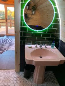 a bathroom with a sink and a mirror at Fox’s Furrow Quirky Glamping Pod with Private Hot Tub 