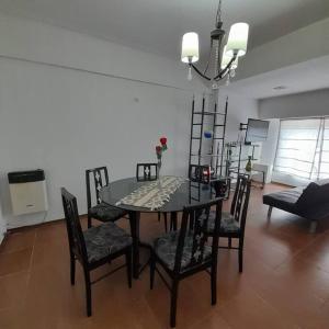 a dining table and chairs in a living room at Alquiler temporario 3 amb Parque Luro Mar del Plata in Mar del Plata