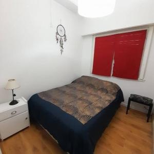 1 dormitorio con cama, mesa y ventana en Alquiler temporario 3 amb Parque Luro Mar del Plata en Mar del Plata