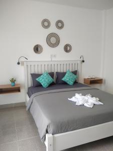 um quarto com uma cama grande e almofadas azuis em Anjo Maumere Hotel & Restaurant em Nangalima