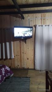 TV en una habitación con cortina y pantalla en Veniteconmigo, en Punta del Diablo