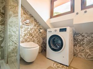 een badkamer met een wasmachine en een toilet bij Schloss Sissi in Pfunds