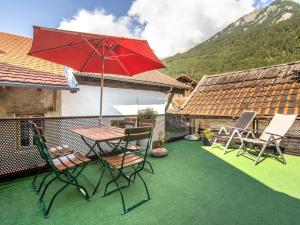 een patio met een tafel en stoelen en een parasol bij Schloss Sissi in Pfunds