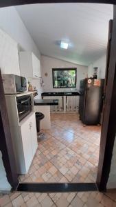 a large kitchen with a tile floor and appliances at Sossego Da Mata in Santo Antônio do Leite