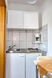 een keuken met witte kasten en een wastafel bij Studio Vodice 6178e in Vodice