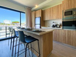 a kitchen with a bar with stools and a counter top at Beautiful + Luxury + Ocean View + Pool in Playa del Carmen