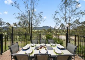 a table and chairs on a patio with a fence at Cants Cottage in Broke