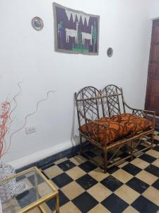 Casa de Barro Tilcara في تيلكارا: غرفة بها كرسي ودهان على الحائط