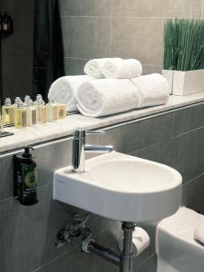 a bathroom with a sink and towels on a shelf at Sydney Boutique Hotel in Sydney