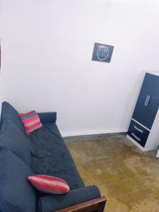 蒂爾卡拉的住宿－Casa de Barro Tilcara，墙上挂着时钟的房间里一张蓝色的沙发