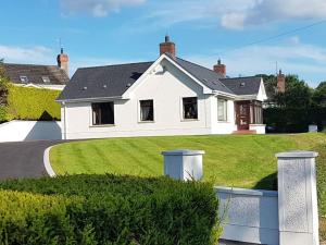 a white house with a yard with a driveway at Sunnyside Lodge - Beautiful Fermanagh Holiday Home 