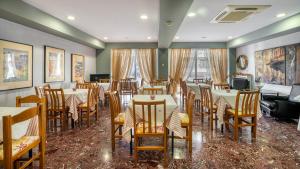 um restaurante com mesas e cadeiras num quarto em Diros Hotel em Atenas