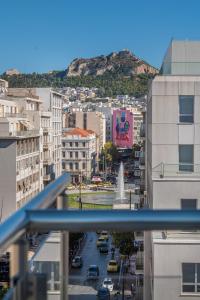 Blick auf eine Stadt mit Gebäuden und einem Brunnen in der Unterkunft Diros Hotel in Athen
