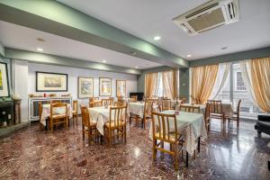 un ristorante con tavoli, sedie e un pianoforte di Diros Hotel ad Atene