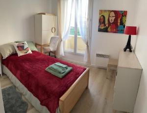 1 dormitorio con cama, escritorio y ventana en Maison agréable et spacieuse aux portes de Paris et du métro en Saint-Ouen