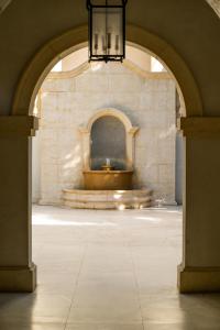 an archway with a fountain in a stone building at The Regent Grand in Grace Bay