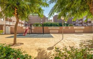 a playground with a slide and a tree at Amazing Apartment In Santa Pola in Santa Pola